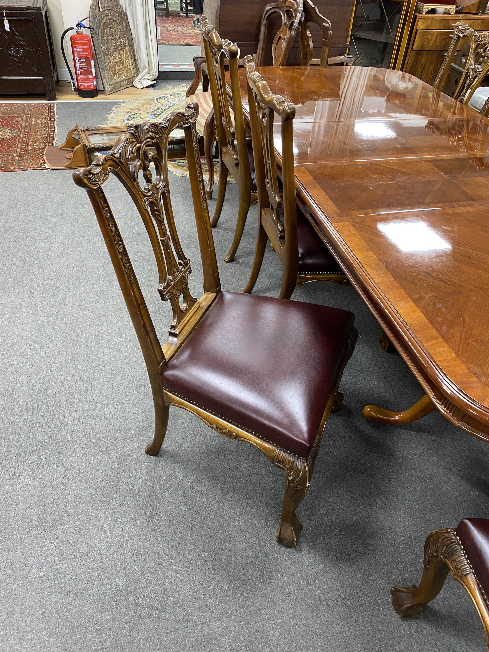 A reproduction inlaid mahogany twin pillar extending dining table, approx. 250cm extended, two spare leaves, width 110cm, height 75cm, together with eight Chippendale style mahogany dining chairs, two with arms